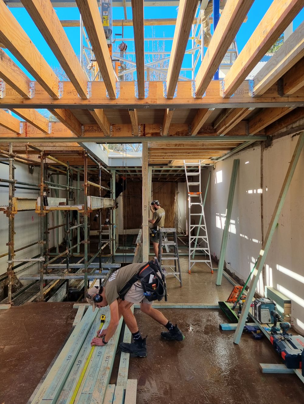 Flynnbuild carpenter measuring structural timber framing on site